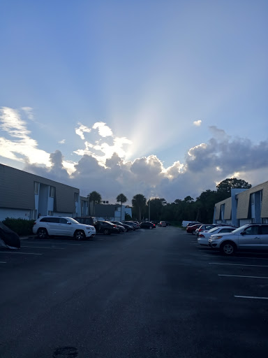 A serene view of a parking lot under a bright sky with rays of sunlight breaking through the clouds.