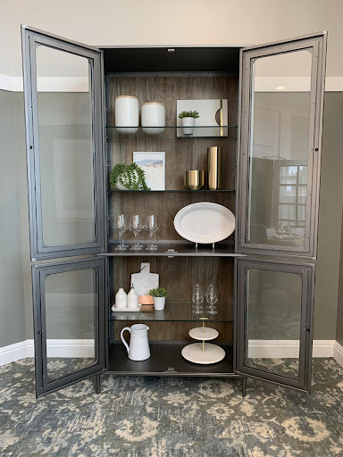 A stylish cabinet showcasing elegant dishware and home decor.