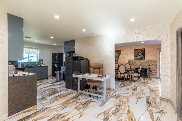 A modern open floor plan featuring a stylish kitchen and adjacent dining area with elegant marble flooring.