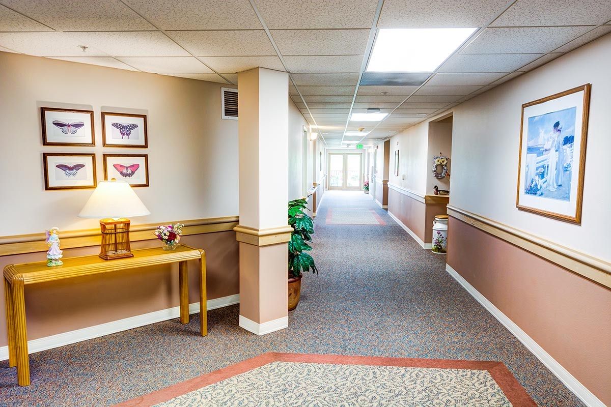 A well-lit hallway in an office building with carpeted flooring and simple decor.