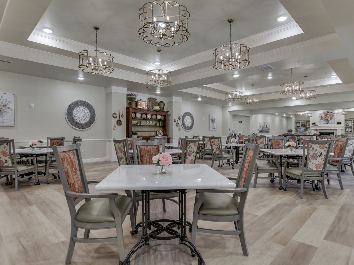 Elegant dining room with chandeliers and neatly arranged tables.