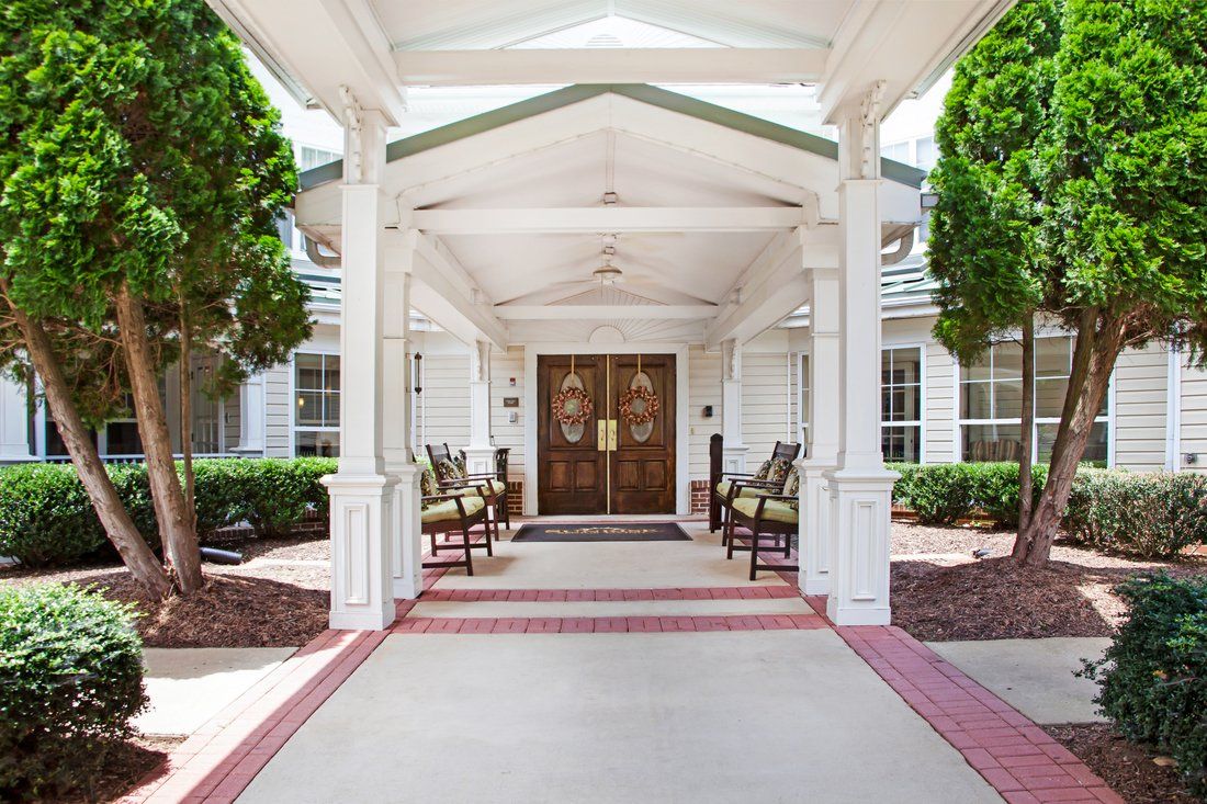 A welcoming entrance to a building with seating and greenery.