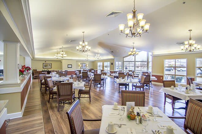 An elegant dining room with neatly arranged tables and warm lighting.