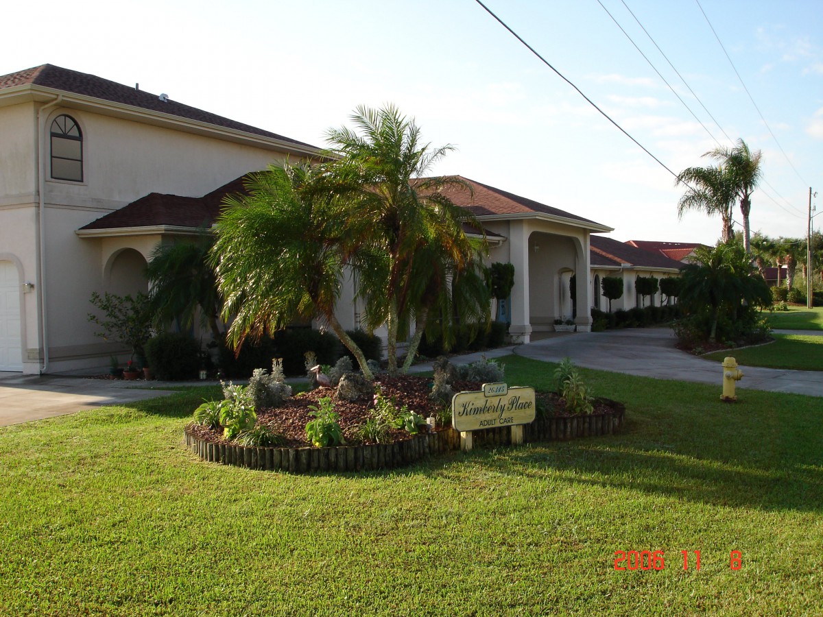 A well-maintained house with a palm tree and vibrant landscaping in the front yard.