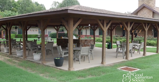 A spacious outdoor pavilion featuring wooden pillars and seating, ideal for gatherings.