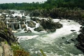 A scenic view of a river with cascading waterfalls and surrounding greenery.