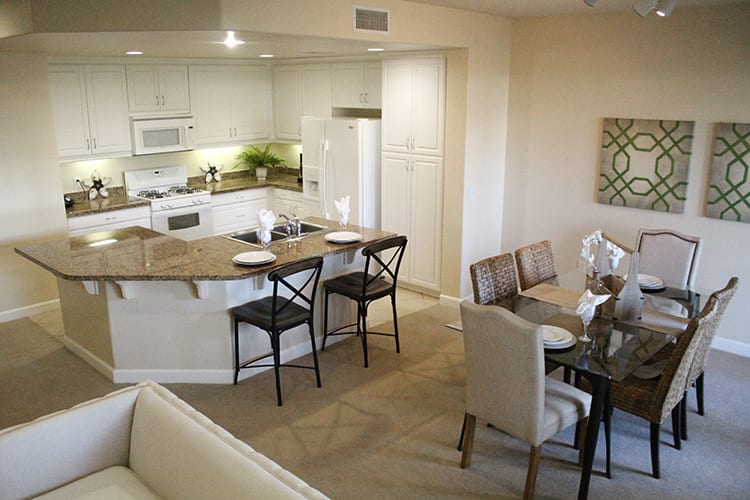 A modern open-plan kitchen and dining area with white cabinetry and stylish seating.