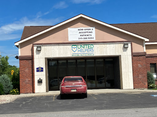 Exterior view of a United healthcare clinic with a red car parked in front.