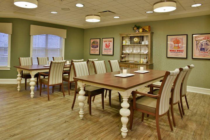 A well-furnished dining room with wooden tables and chairs, featuring elegant decor and wood flooring.