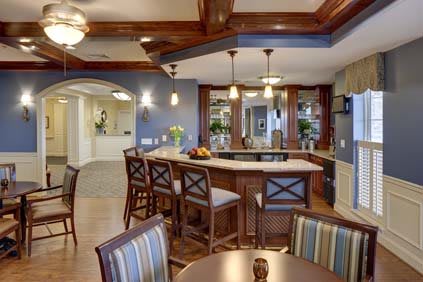 A stylish kitchen with a bar area, featuring pendant lights and wooden accents.