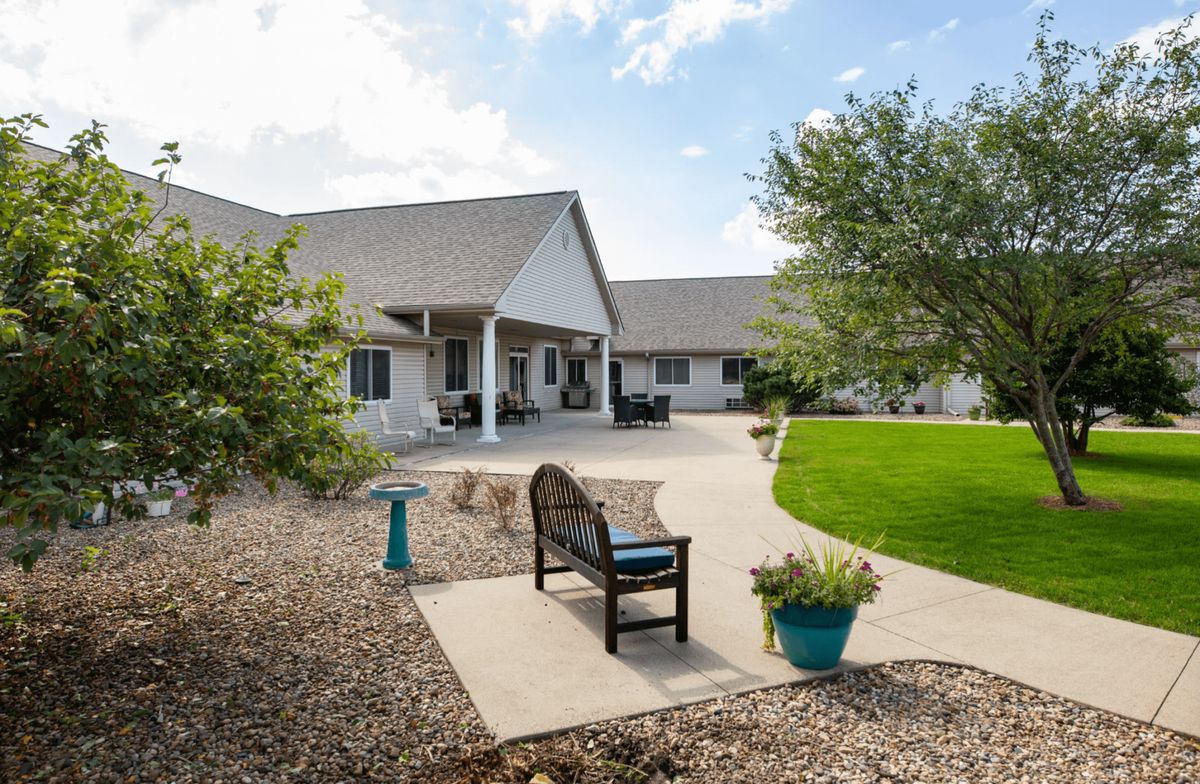 A cozy backyard with a well-maintained lawn, patio seating, and decorative elements.