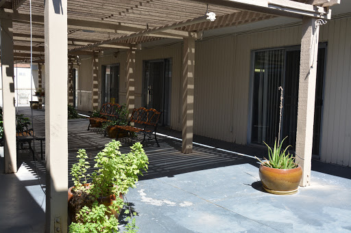 A serene patio area featuring shaded seating and decorative plants.