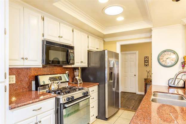 A modern kitchen with stainless steel appliances and white cabinets.