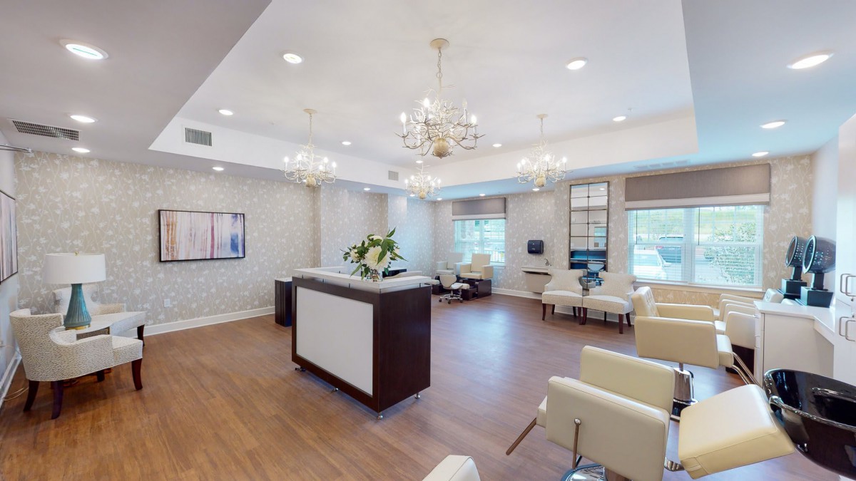A modern reception area with chandeliers and comfortable seating.