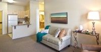 A cozy living room with a comfortable sofa and a landscape painting on the wall.