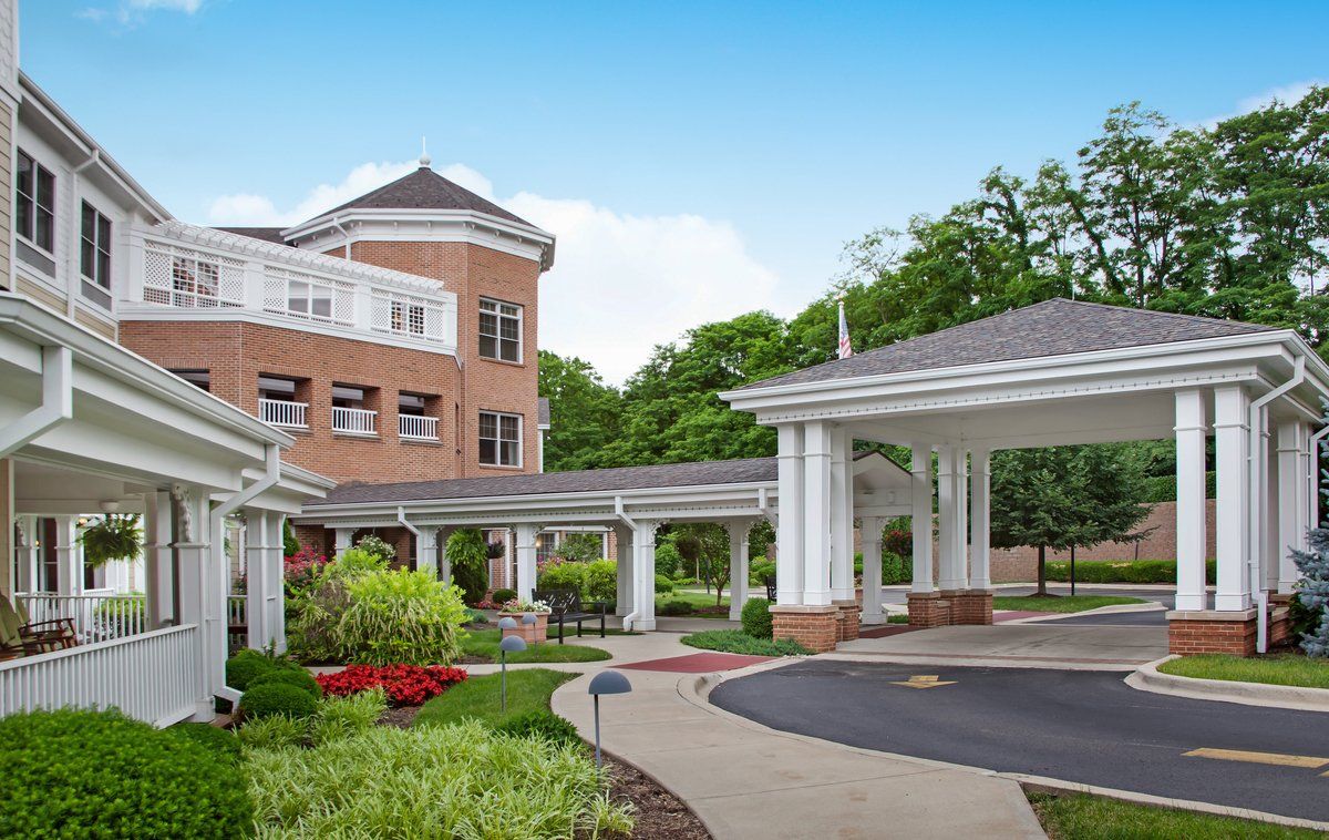 A modern hospital building with landscaped surroundings and a covered driveway.