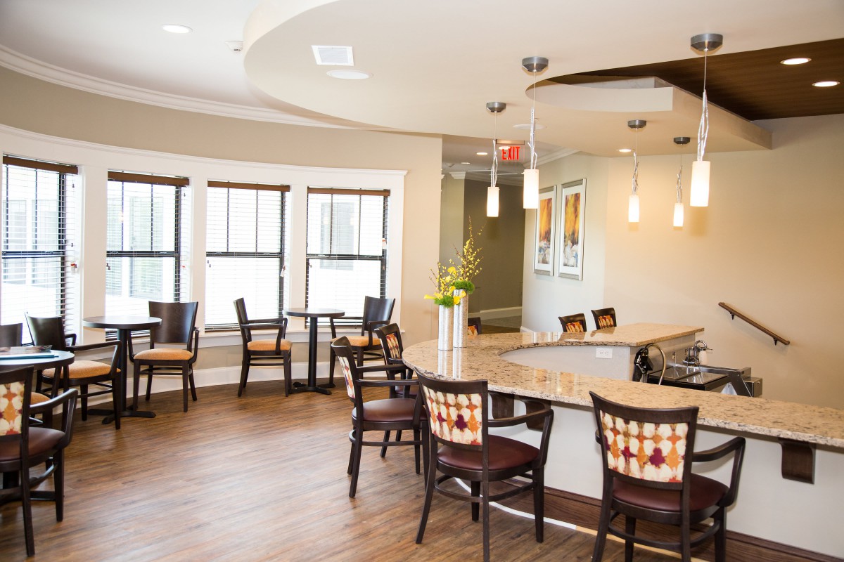 A modern dining area with wooden flooring and elegant pendant lighting.