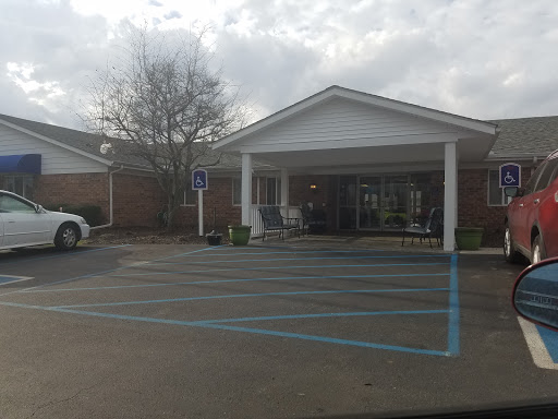 A view of a residential building with a parking lot on a cloudy day.