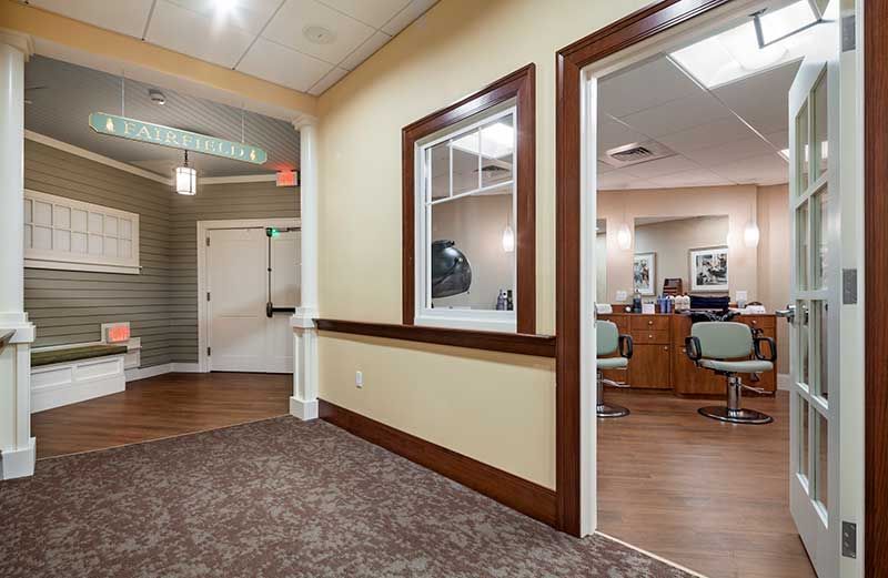 An interior view of an office hallway leading to a waiting area and reception desk.