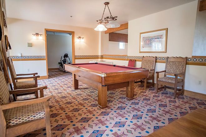 A cozy game room featuring a pool table and comfortable seating.