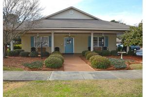 A suburban house with a front porch and landscaped yard.
