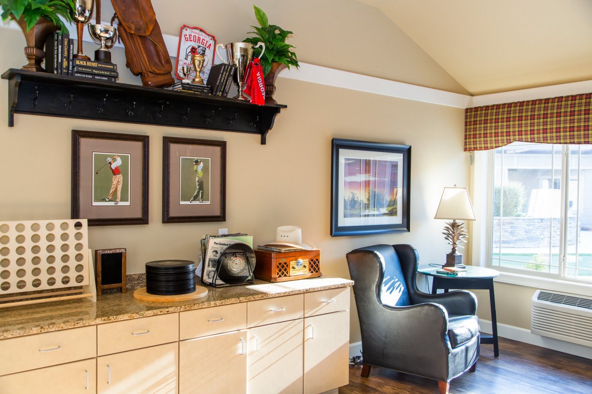 A cozy home office with decorative shelves, elegant artwork, and a comfortable leather chair.
