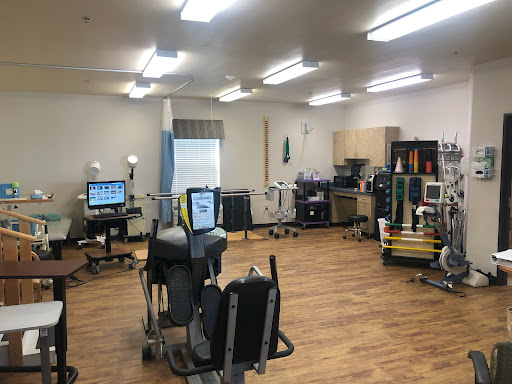 A well-equipped rehabilitation therapy room with various exercise machines and therapeutic devices.
