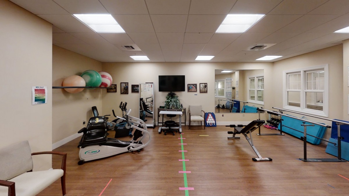 A well-equipped gym with various exercise machines and weights.