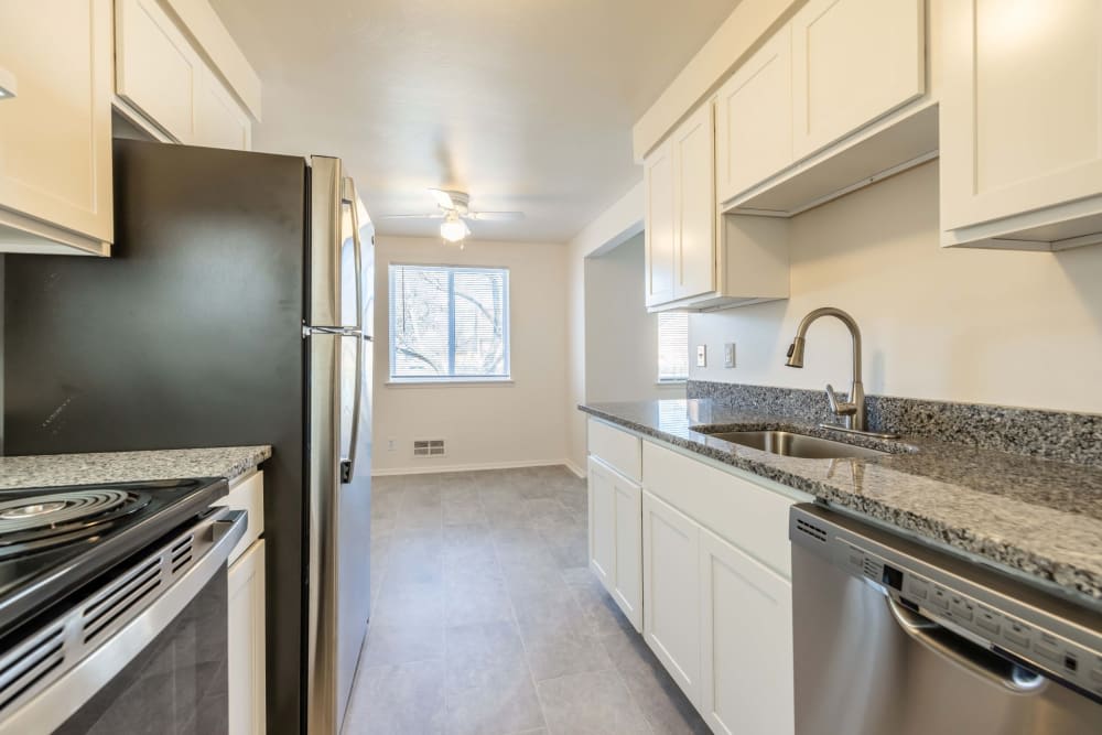 A modern kitchen with stainless steel appliances and white cabinets.