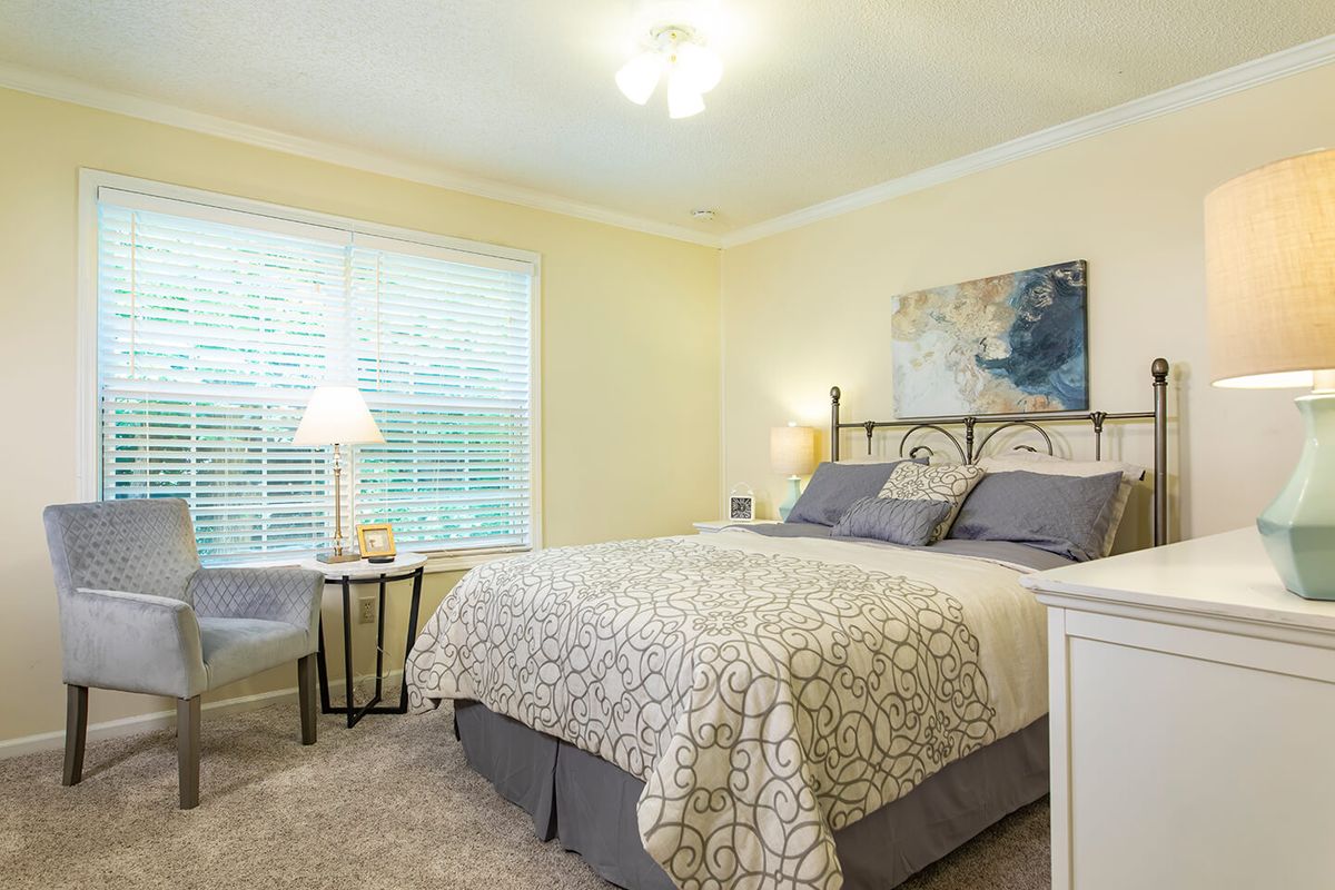A cozy bedroom with a neatly made bed, bedside lamps, and tasteful decorations.