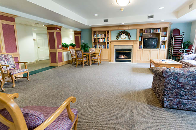 A cozy living room with a fireplace, bookshelves, and comfortable seating.