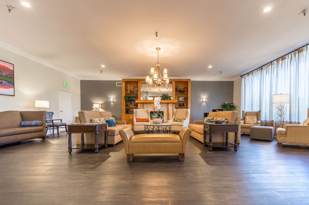 A spacious, modern living room with elegant furniture and lighting.