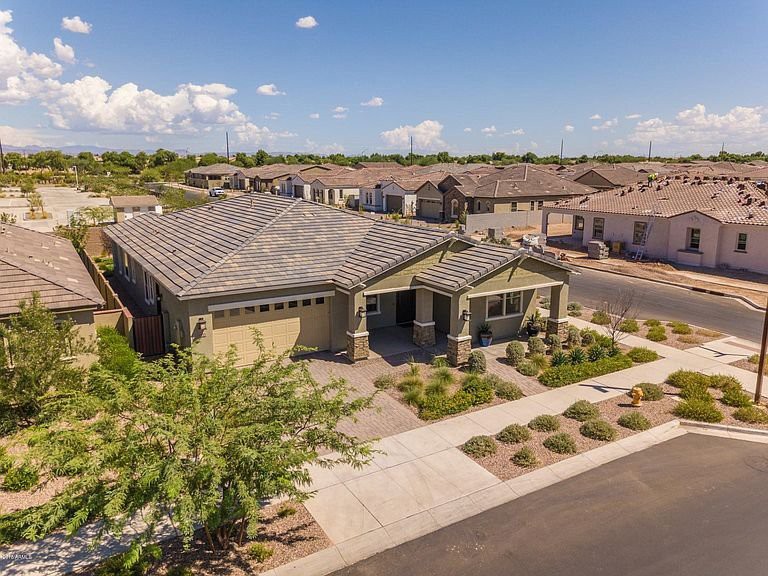 Aerial view of a modern suburban house with well-maintained landscaping.