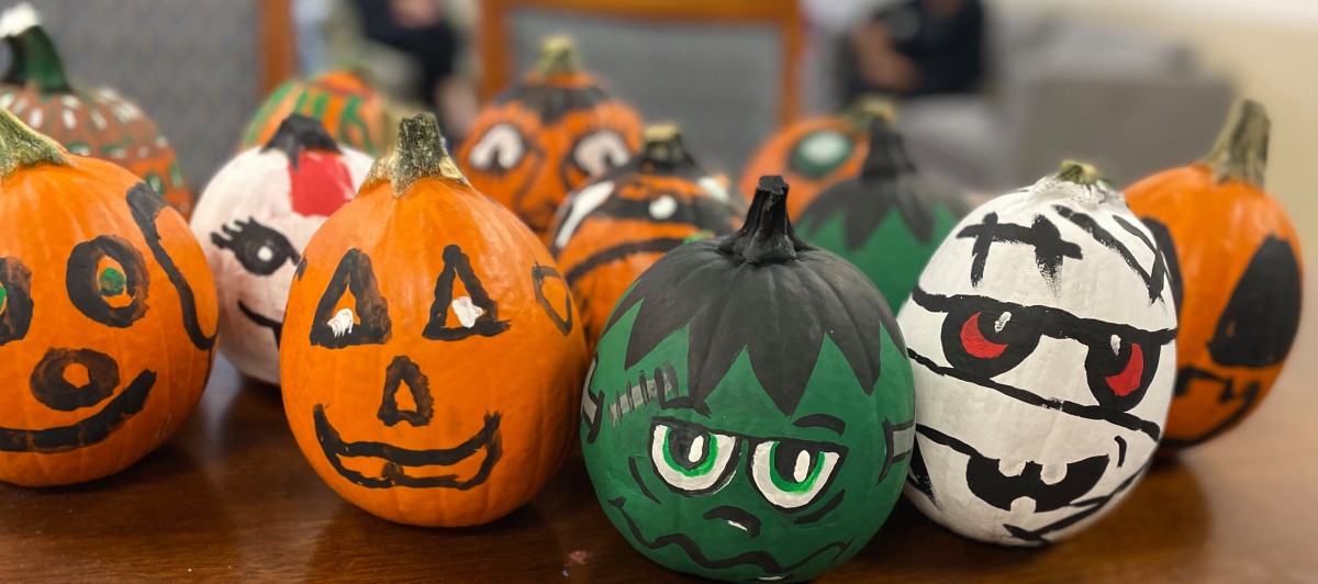 Colorful painted pumpkins with creative Halloween designs.