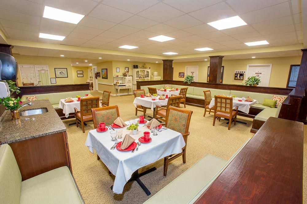 A well-furnished dining area with neatly arranged tables and chairs, featuring warm lighting and tasteful decor.