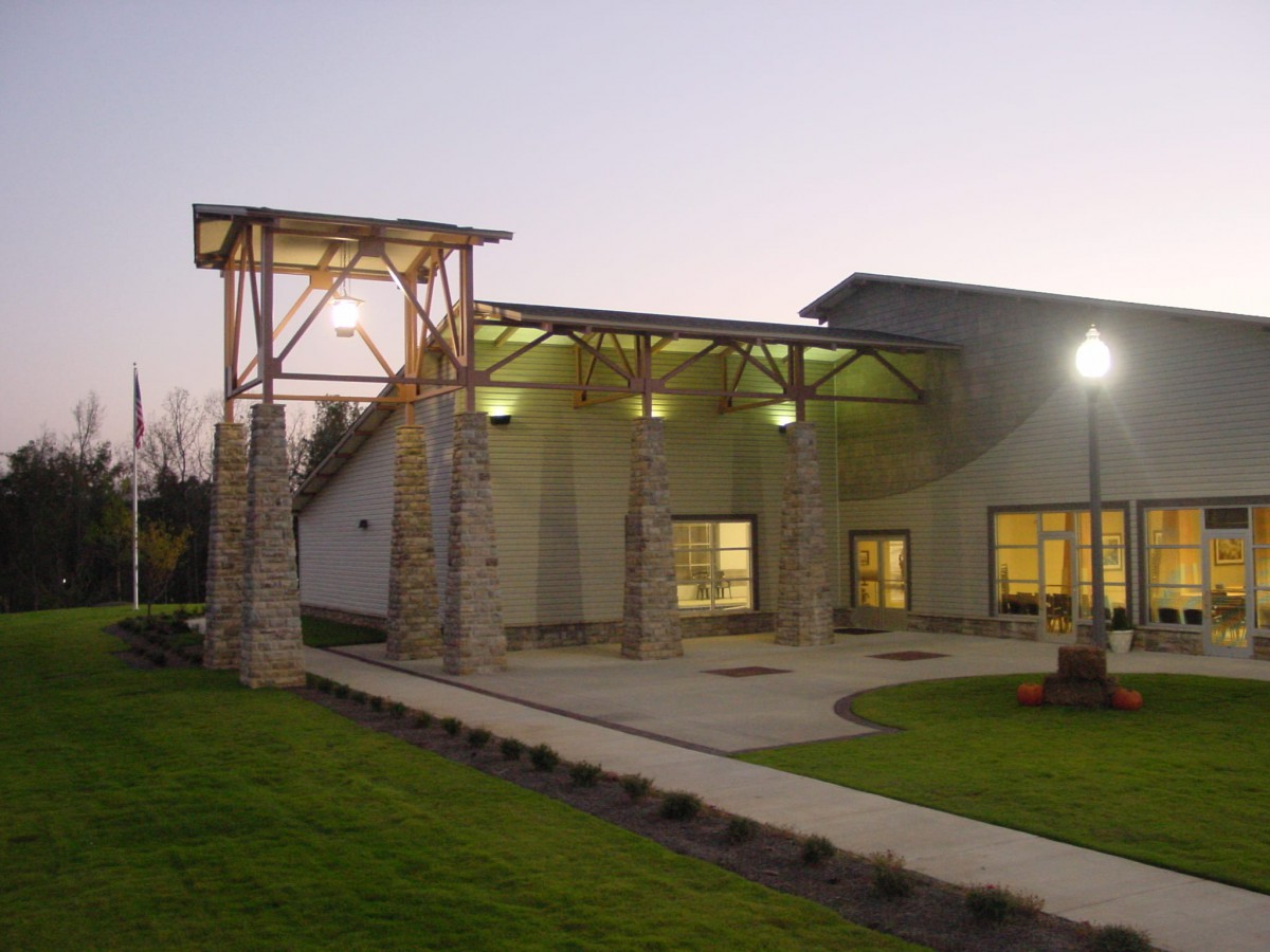 A modern building with lit exterior lights at dusk.
