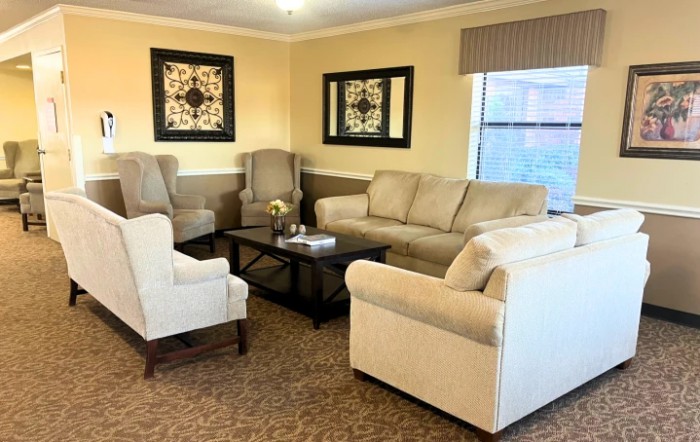 A cozy living room with a beige sofa, matching armchairs, and elegant decor.