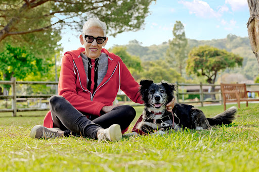 A person enjoying a sunny day in the park with their dog.