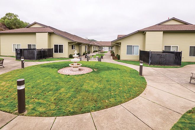 A well-maintained courtyard with a fountain, surrounded by residential buildings and walkways.