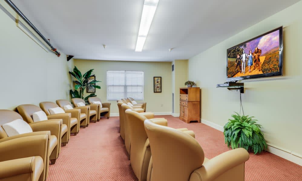 A comfortable waiting room with several chairs and a television.