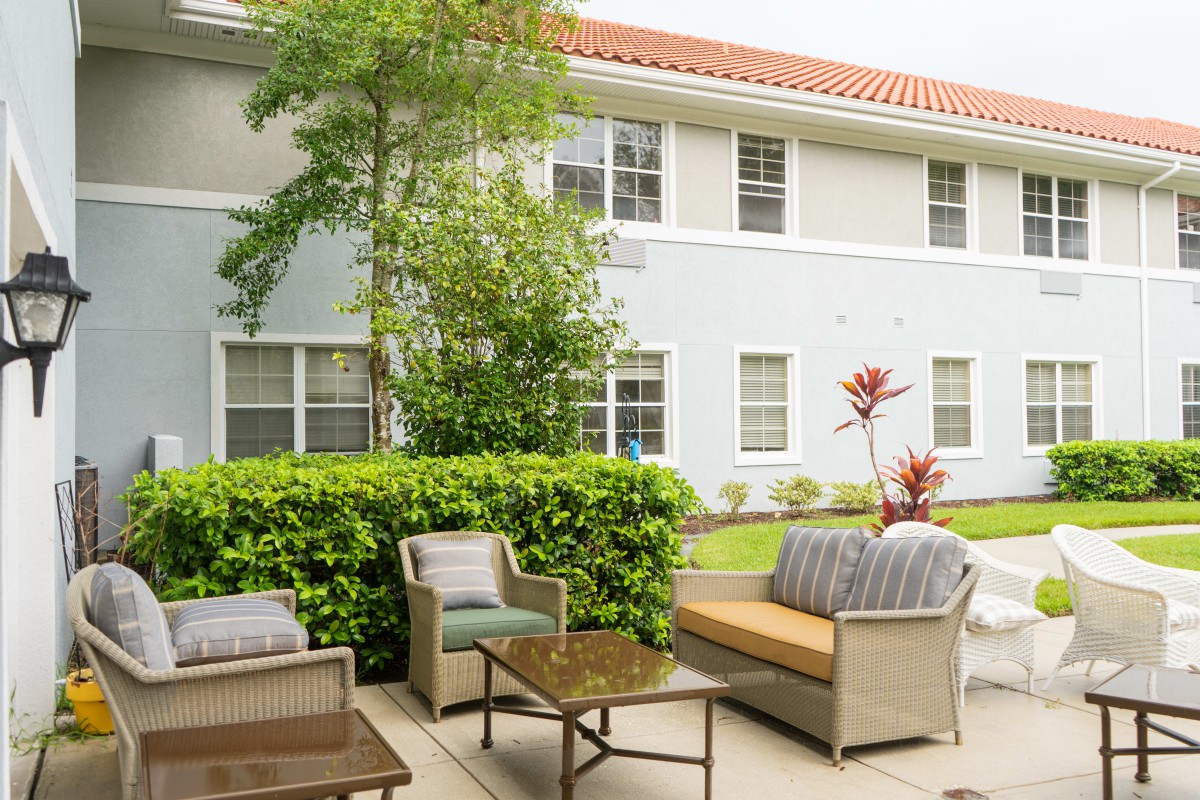 A cozy patio area with outdoor furniture set against a residential building backdrop.