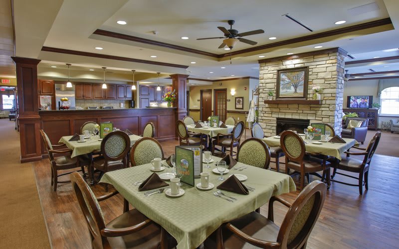 A well-lit restaurant dining area with neatly arranged tables and chairs.