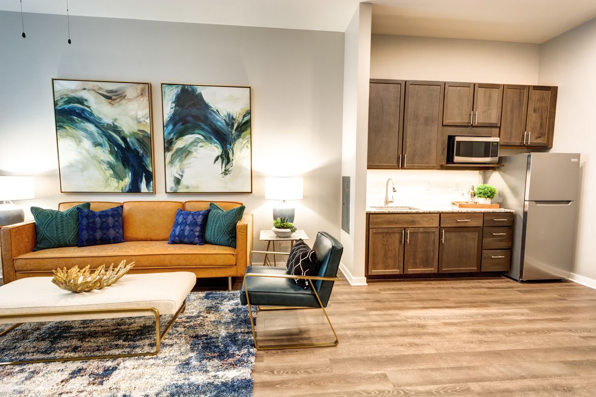 A modern living room with vibrant artwork and an open kitchen.