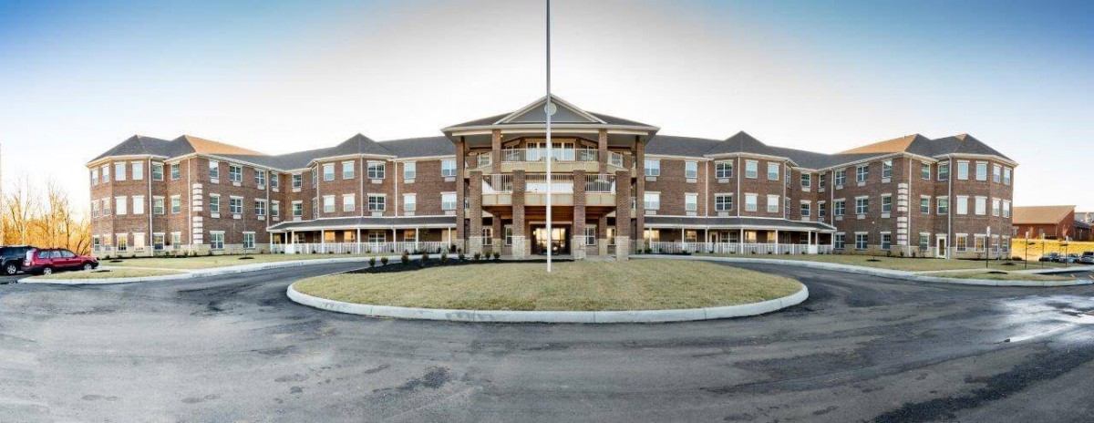A large, multi-story building with a grand entrance and circular driveway.