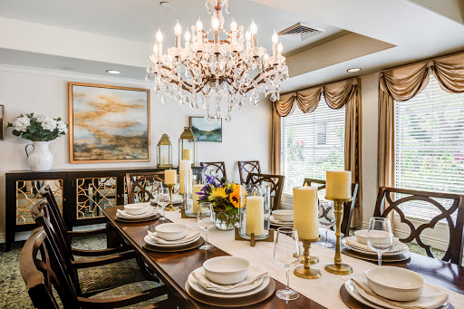 An elegantly arranged dining room featuring a stunning chandelier and beautiful floral centerpieces.