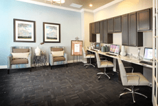 Modern office workspace with computers and seating area.