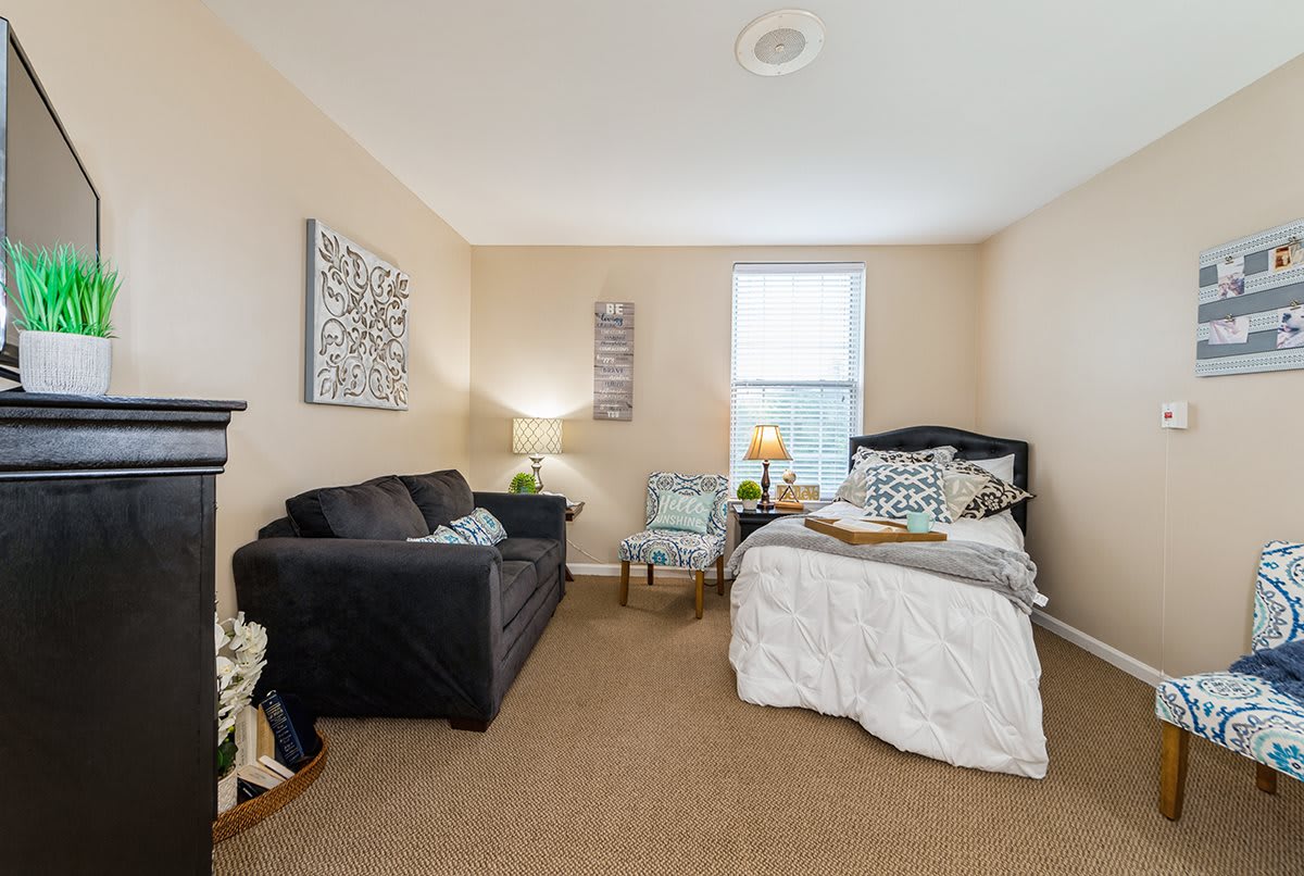A cozy bedroom with a bed, sofa, and elegant decor.