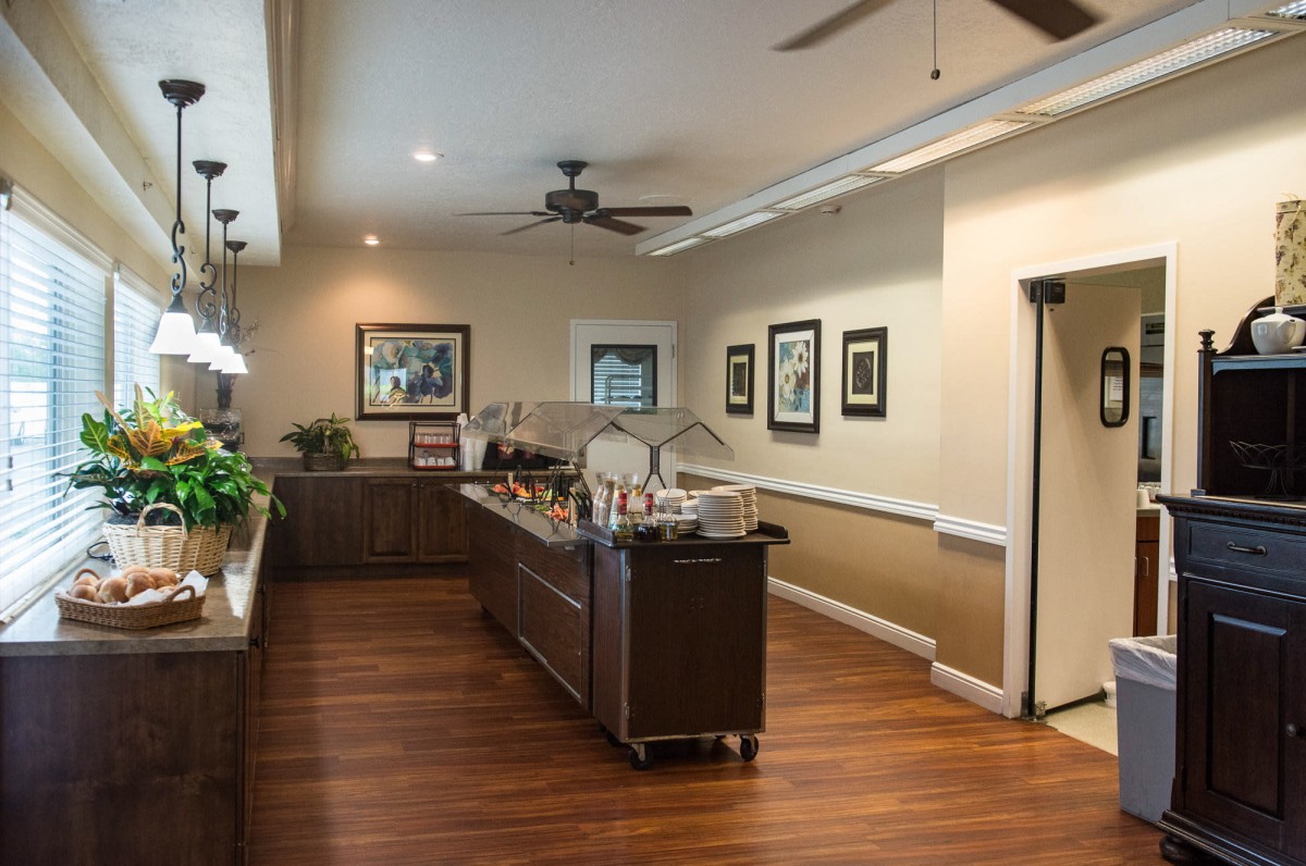 A modern kitchen interior with wooden flooring, featuring a central island and ceiling fan.