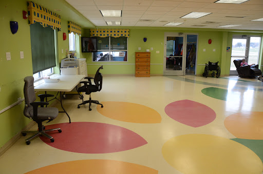 A vibrant playroom featuring colorful flooring and green walls, designed to create a welcoming environment for children.