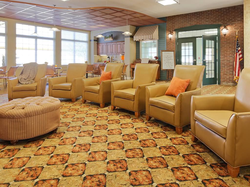 A cozy lounge area with several armchairs and a patterned carpet.